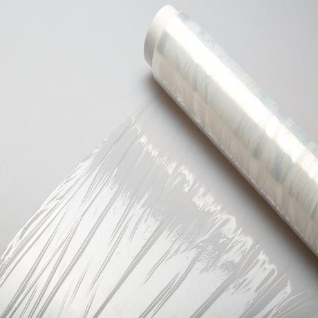 A roll of clear plastic wrap on a white surface.