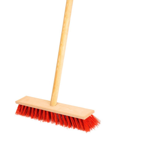 A red broom with wooden handle on a white background.